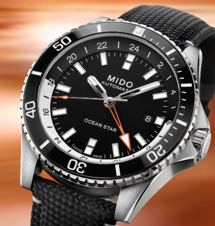 MIDO Ocean Star GMT M026.629.17.051.01 的橘色 GMT 指針、黑白 24 小時內圈與織物風格錶帶